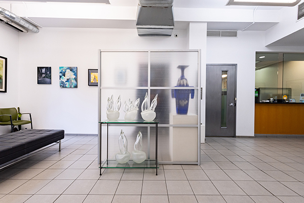 An image of a modern, well-lit interior space featuring a reception area with a glass partition, display cases showcasing various items, and a contemporary decor style.