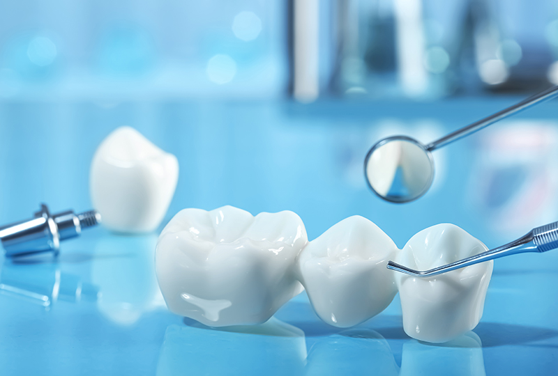 The image displays a collection of white dental implants on a blue surface, with dental tools and a syringe nearby, suggesting a dental care or dental implant context.